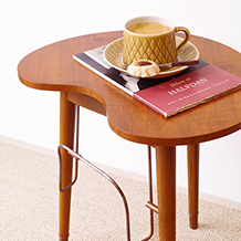 Kidney shaped table with newspaper holder